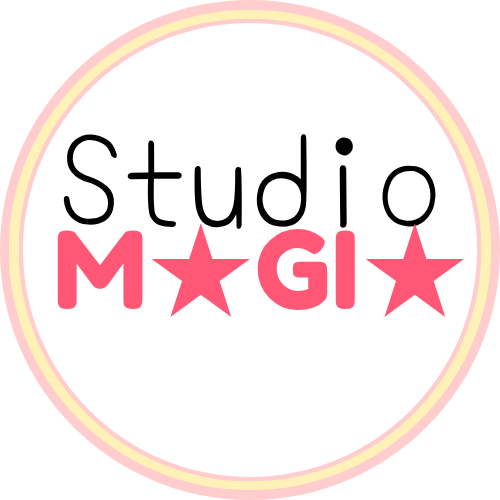 A transparent image of the logo of Studio Magia. It has a thick circular outline colored light-pink wtih a light yellow line dividing the outline into two. Inside, are the words 'Studio Magia', with 'Magia' written in all caps, with both A's replaced with stars, and in pink.